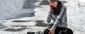 Frau telefoniert, nachdem sie auf Eis ausgerutscht ist