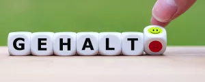 Hand dreht einen Würfel und damit ändert einen wütenden Emoji in einen glücklichen Emoji. 