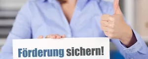 Frau mit Schild "Förderung sichern"