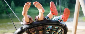 Kinder auf einer Schaukel am Spielplatz