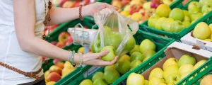 Frau packt Äpfel in Sackerl