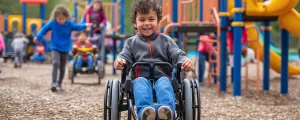 Kind im Rollstuhl auf einem Spielplatz