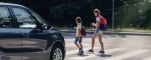 Kinder überqueren eine Straße auf einem Zebrastreifen
