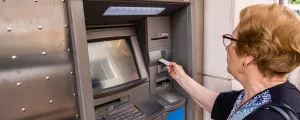Frau behebt Geld von einem Bankomat