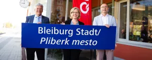 Kärntens Landeshauptmann Peter Kaiser, Ministerin Leonore Gewessler und ÖBB-Infrastruktur-Vorstand mit der neuen Stationstafel in St. Michael ob Bleiburg / Šmihel pri Pliberku