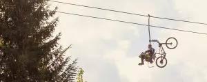 Mann mit Mountainbike auf einem Sessellift