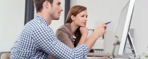Mann und Frau schauen auf einen Computer