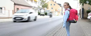 Schulkind möchte eine belebte Straße überqueren