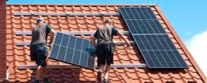 Männer montieren PV-Anlage auf einem Dach