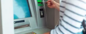 Frau behebt Geld von einem Bankomat