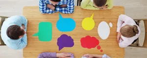 Menschen sitzen an einem Tisch und diskutieren