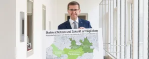 Wirtschafts- und Raumordnungs-Landesrat Markus Achleitner mit einer Karte der beiden bereits bestehenden Grünzonen sowie der derzeit in Umsetzung befindlichen regionalen Grünzone in Wels-Grieskirchen.