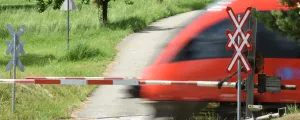 Zug fährt bei Bahnschranken vorbei