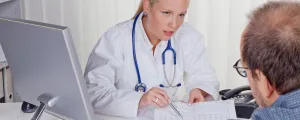 Ärztin mit Stethoskop spricht mit Patienten