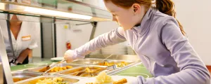 Kind nimmt sich Essen von einem Buffetwagen