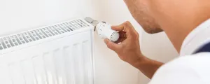Mann dreht Temperatur zurück