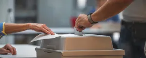 Wähler wirft seinen Stimmzettel in die Wahlurne