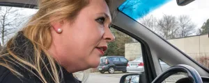 Frau am Steuer eines Autos sucht Parkplatz 