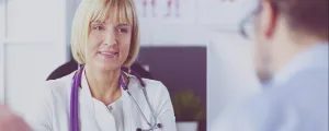 Ärztin mit Stethoskop spricht mit Patienten