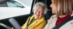 Frau fährt Seniorin zum Arzt