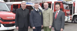 Alfred Riedl und andere Kommunalpolitiker vor Feuerwehrautos