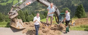 Kommunalpolitiker mit Schaufeln und Bagger