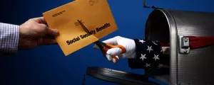 Schere reicht aus Postkasten und zerschneidet Brief