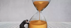 Mann versucht Sanduhr umzustürzen