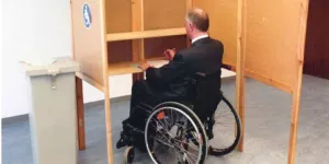 Rollstuhlfahrer in einer Wahlkabine