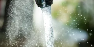 Wasser rinnt aus Hahn