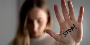 Frau zeigt Handfläche mit Aufschrift Stop