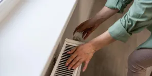 Frau dreht Heizung auf