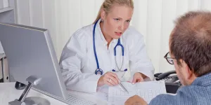 Ärztin mit Stethoskop spricht mit Patienten