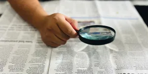 Zeitung mit Lupe lesen