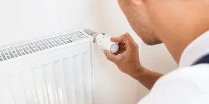 Mann dreht Temperatur zurück