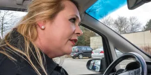 Frau am Steuer eines Autos sucht Parkplatz 