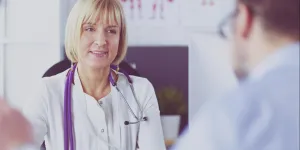 Ärztin mit Stethoskop spricht mit Patienten