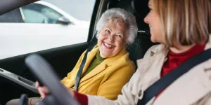 Frau fährt Seniorin zum Arzt