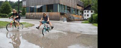 Hinterstoder - Kinder mit Fahrrädern im Regen