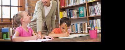 Frau betreut zwei Kinder in der Schule
