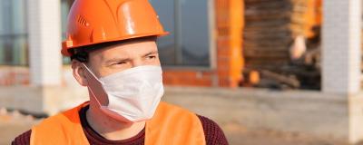 Bauarbeiter mit Nasen-Mund-Schutz
