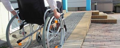 Frau im Rollstuhl auf Rollstuhlrampe