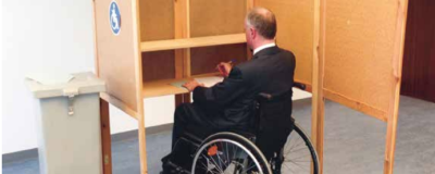 Rollstuhlfahrer in einer Wahlkabine