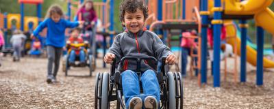 Kind im Rollstuhl auf einem Spielplatz