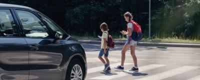 Kinder überqueren eine Straße auf einem Zebrastreifen