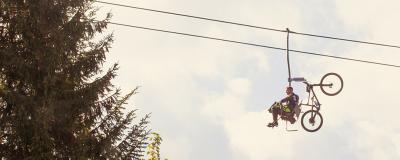 Mann mit Mountainbike auf einem Sessellift