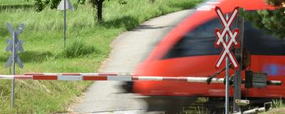 Zug fährt bei Bahnschranken vorbei
