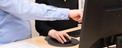 a man and a woman working together on a pc, man pointing at screen