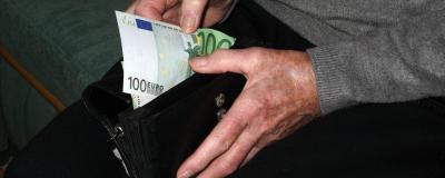 Mann zieht Geldschein aus Geldbörse