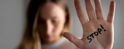 Frau zeigt Handfläche mit Aufschrift Stop